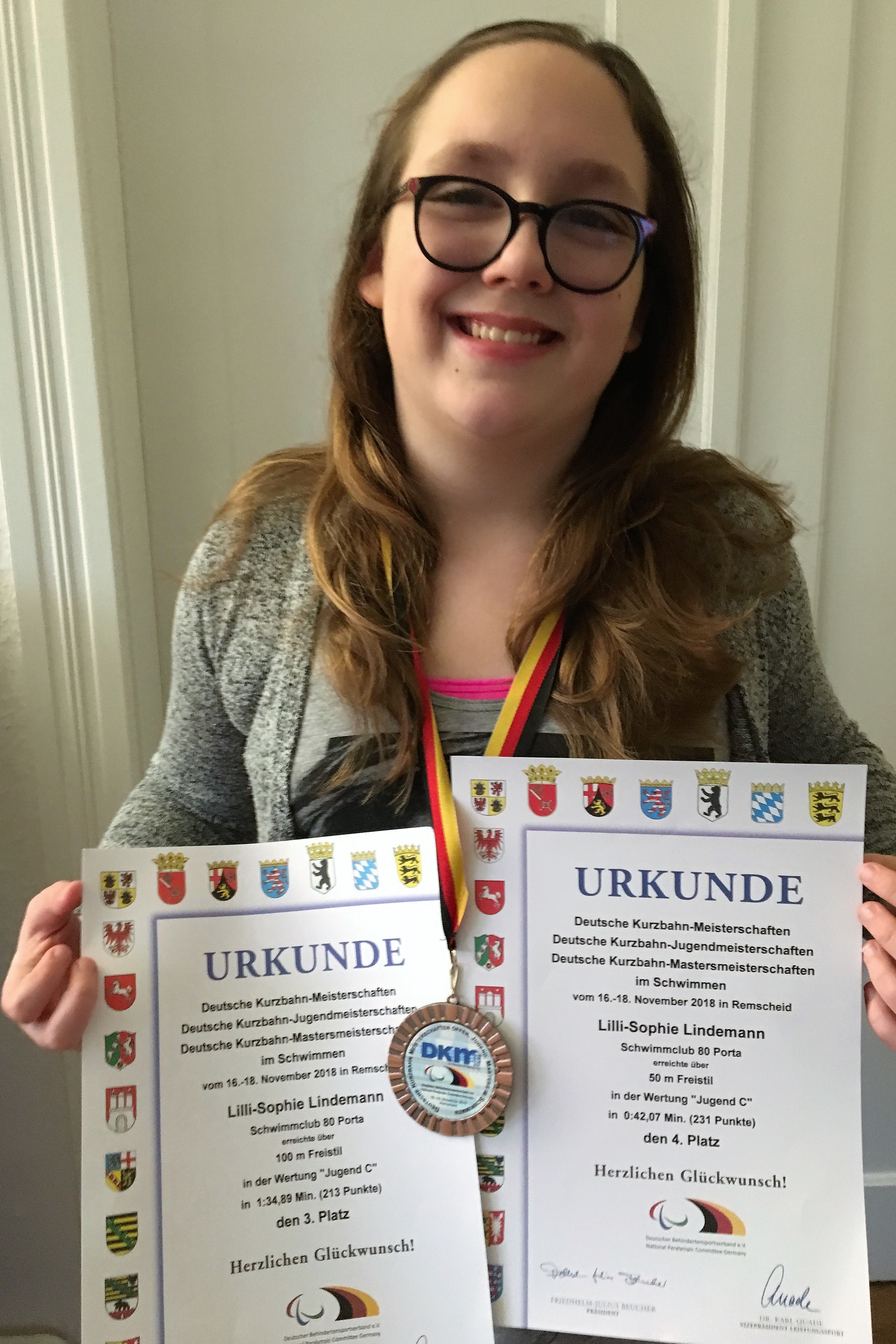 Lilli-Sophie Lindemann präsentiert ganz stolz ihre Urkunden und Medaillen.